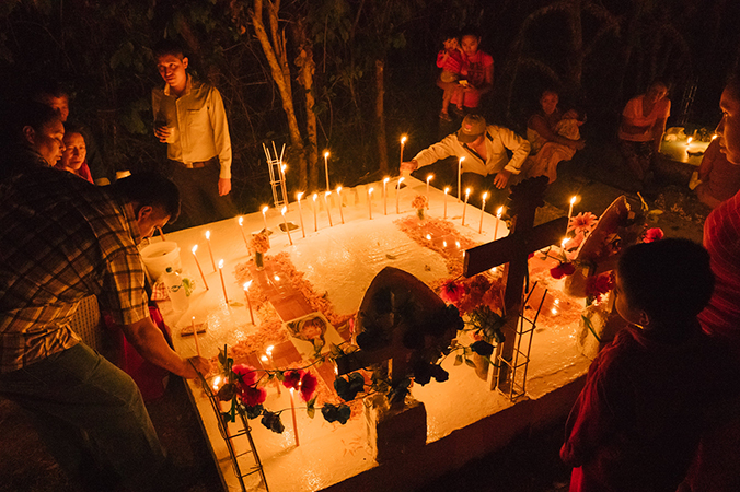 los familiares comienzan a adornar la tumba de sus familiares con velas y elementos indispensables para hacer la ofrenda