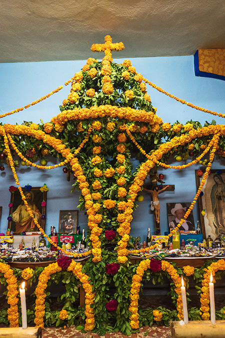 así es como son los altares de muerto en la cultura mexicana en el xantolo, se adorna con muchas flores de cempasúchil, fotografías de los difuntos, comida, velas, entre otras cosas